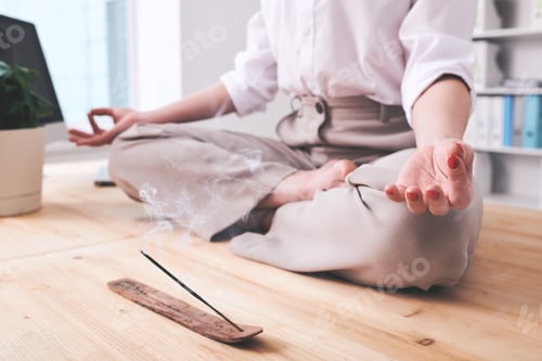 Preview: Hand and crossed legs of meditating young businesswoman in formalwear