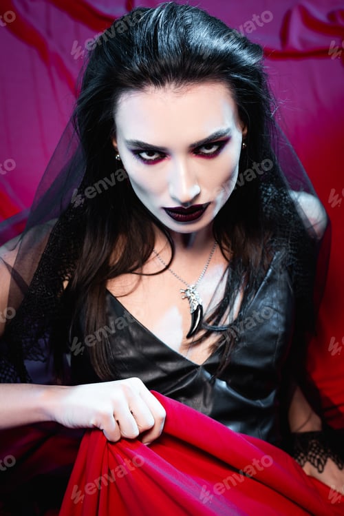Preview: high angle view of brunette and pale woman looking at camera on red