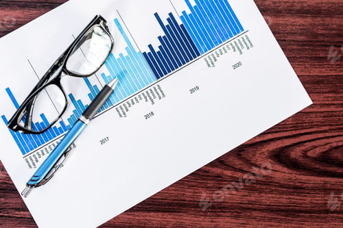 Preview: High angle shot of papers with statistical reports and a pair of glasses on a wooden surface
