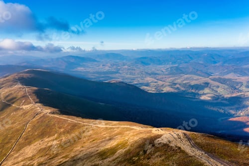Preview: Long pathways running along mountains under blue sky