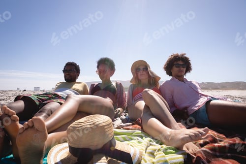Preview: Friends lying and relaxing with sunglasses on the beach