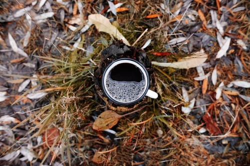 Preview: Iron mug with a hot drink, outdoors. Top view, close-up. Concept for outdoor activities