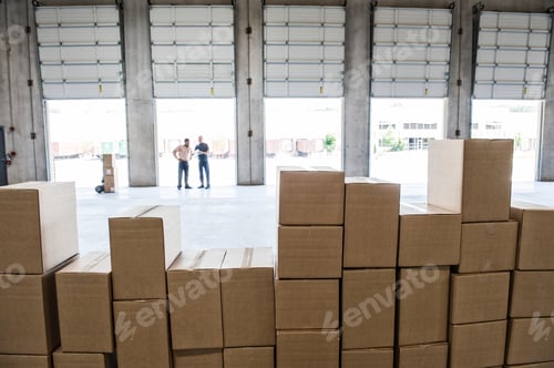 Preview: Team of workers check out inventory in front of loading dock doors in a new warehouse.