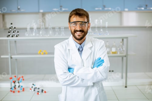Preview: Young scientist in white lab coat standing in the biomedical lab