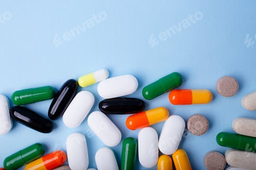 Preview: Front view of different pills on blue background,banner with negative space.