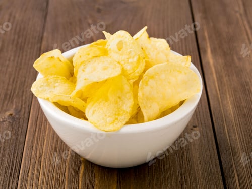 Preview: potato chips in white bowl on brown wooden table