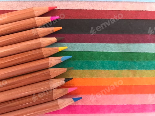 Preview: Color pencils on background of multicoloured tissue paper with copy space, bright and colorful