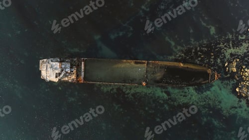 Preview: Aerial top view for wrecked ship along the rocky coast in blue water. Shot. Old sunk boat near sea