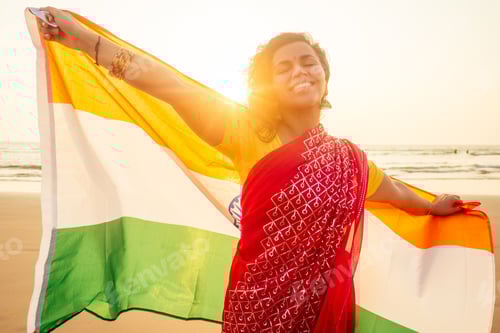 Preview: beautuful woman holding Indian flag tricolour ,wearing red tradition sari on sea beach in Goa