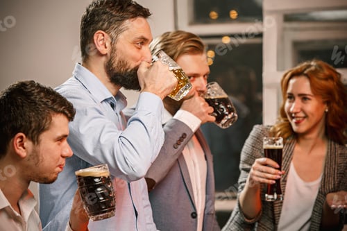 Preview: Group of friends enjoying evening drinks with beer