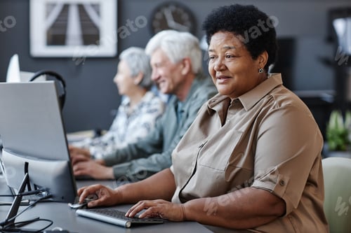 Preview: Senior people using computers in row with black elderly woman typing