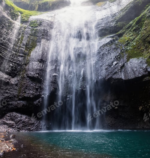 Preview: Majestic waterfall flowing on rocky cliff in tropical rainforest