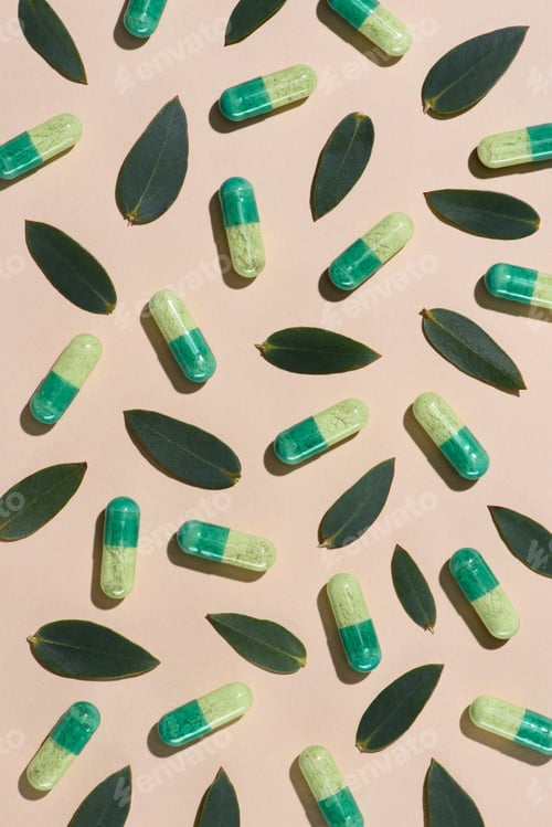 Preview: top view of phytotherapy pills with green leaves pattern on beige surface