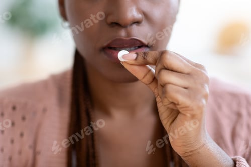 Preview: Unrecognizable Black Lady Taking Medicine At Home, Eating Beauty Supplement Pill
