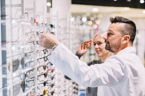 Preview: Optician and his patient choosing glasses.