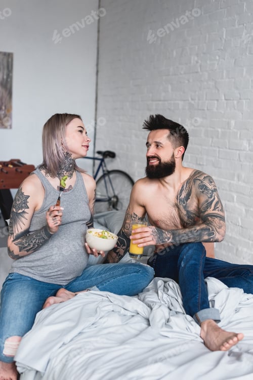 Preview: pregnant tattooed girlfriend eating salad at home