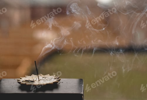 Preview: Aromatic incense burning on a windowsill with smoke