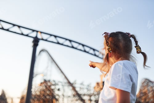 Preview: Little girl have fun at children's amusement park at daytime