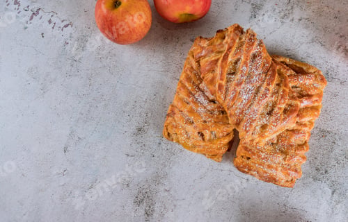 Preview: Homemade apple strudel with red apples on white background.