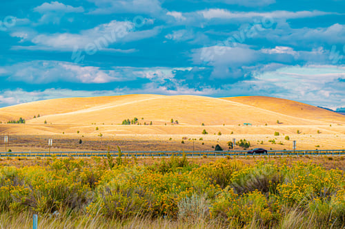 Preview: Rolling hills with highway and car under blue sky