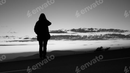 Preview: Silhouette of a lonely person enjoying the beautiful view of the sunset