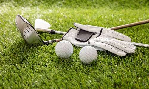 Preview: Golf equipment on green grass golf course, close up view.