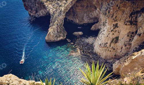 Preview: View of the Blue Grotto and small boats with tourists maneuvering between the rocks in the blue sea
