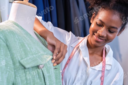 Preview: Attractive Young Asian woman professional fashion designer checking finished cloth in studio room