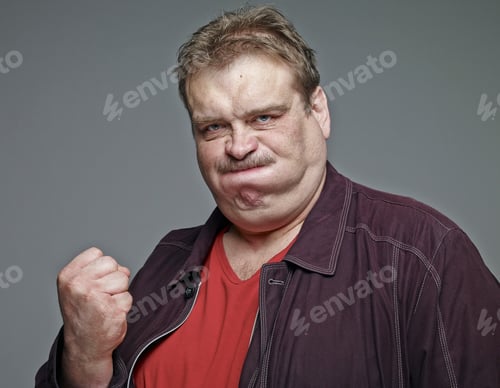 Preview: Portrait of man clenching his fist in front of grey background