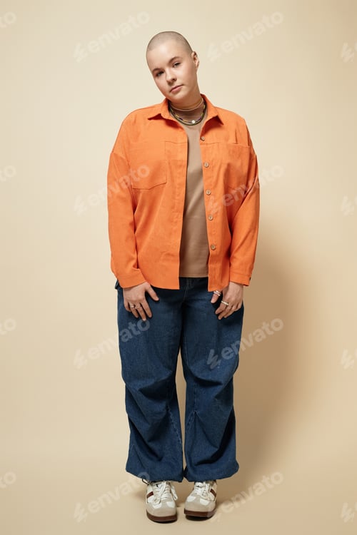 Preview: Bald young woman wearing bright orange shirt