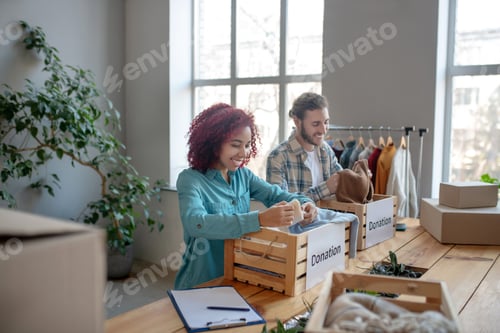 Preview: Young adult man and girl sorting clothes.