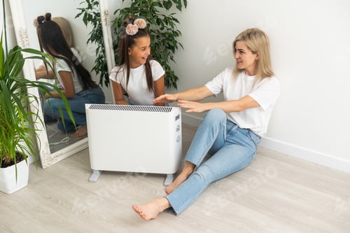 Preview: Cold home, freezing family, mother and daughter Sitting Near Heater