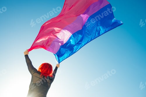 Preview: Beautiful low angle shot of a female waving red and blue flag