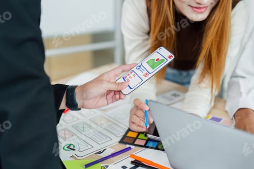 Visualização: Designer de interface de usuário e desenvolvedor de UX discutem ideias para projetar a interface do aplicativo. Digital criativo