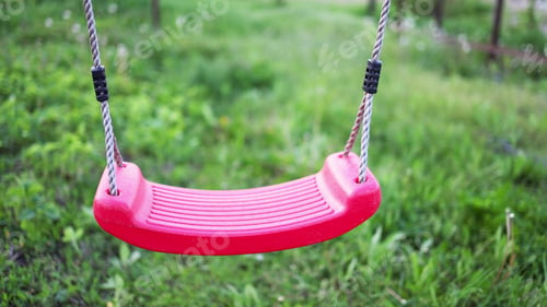 Preview: Lonely swing hanging in a garden full of green grass and trees in springtime