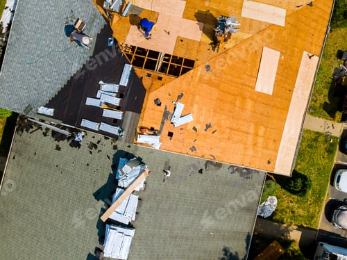 Preview: A worker replace shingles on the roof of a home repairing the roof of home