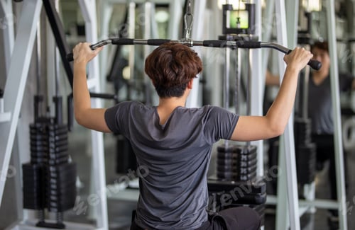 Preview: slim young man exercise at a fitness