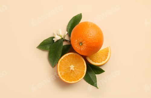 Preview: Fresh ripe oranges with green leaves and flower on beige background, flat lay