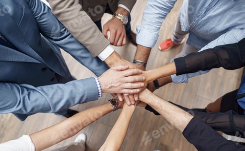 Preview: Top view of group coworkers stacked hands together as concept of corporate unity