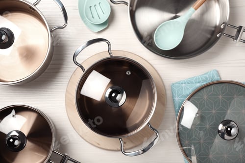 Preview: New cookware set and kitchen utensils on white wooden table, flat lay