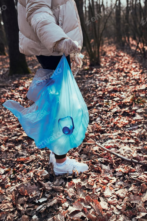 Preview: Young woman cleaning up a forest