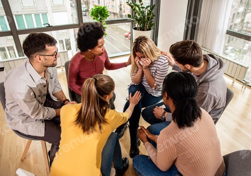 Preview: Diverse group of people sitting in circle in group therapy session.