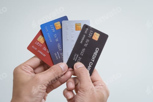 Preview: A close-up of a man’s hand holding a bank credit card against background,emphasizing secure online