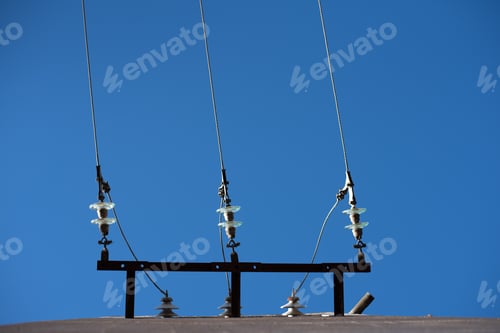 Preview: Electric cables seen from below with blue sky background.