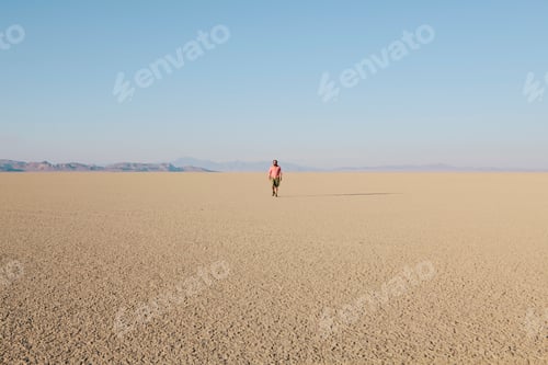 Preview: Man walking across a flat desert landscape