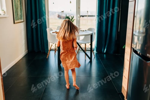 Preview: Little kid happy girl running on the kitchen at cozy home lifestyle authentic moment