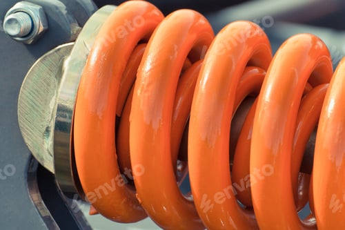 Preview: Hard orange spring made of steel. Part of big industrial or agricultural machine