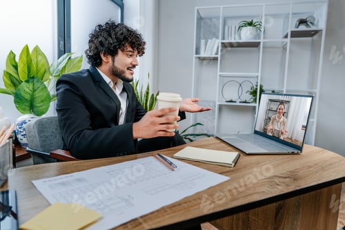 Preview: Businessman using laptop sitting in modern office