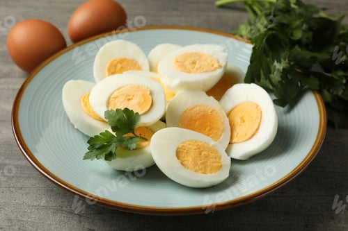 Preview: Plate with boiled eggs and parsley on gray background