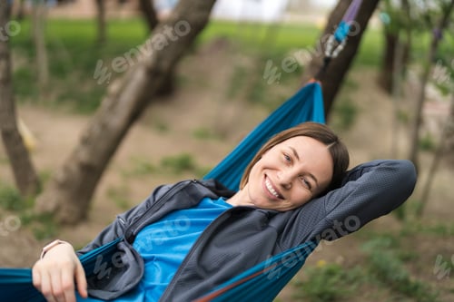 Preview: Smiling woman resting in a hammock
